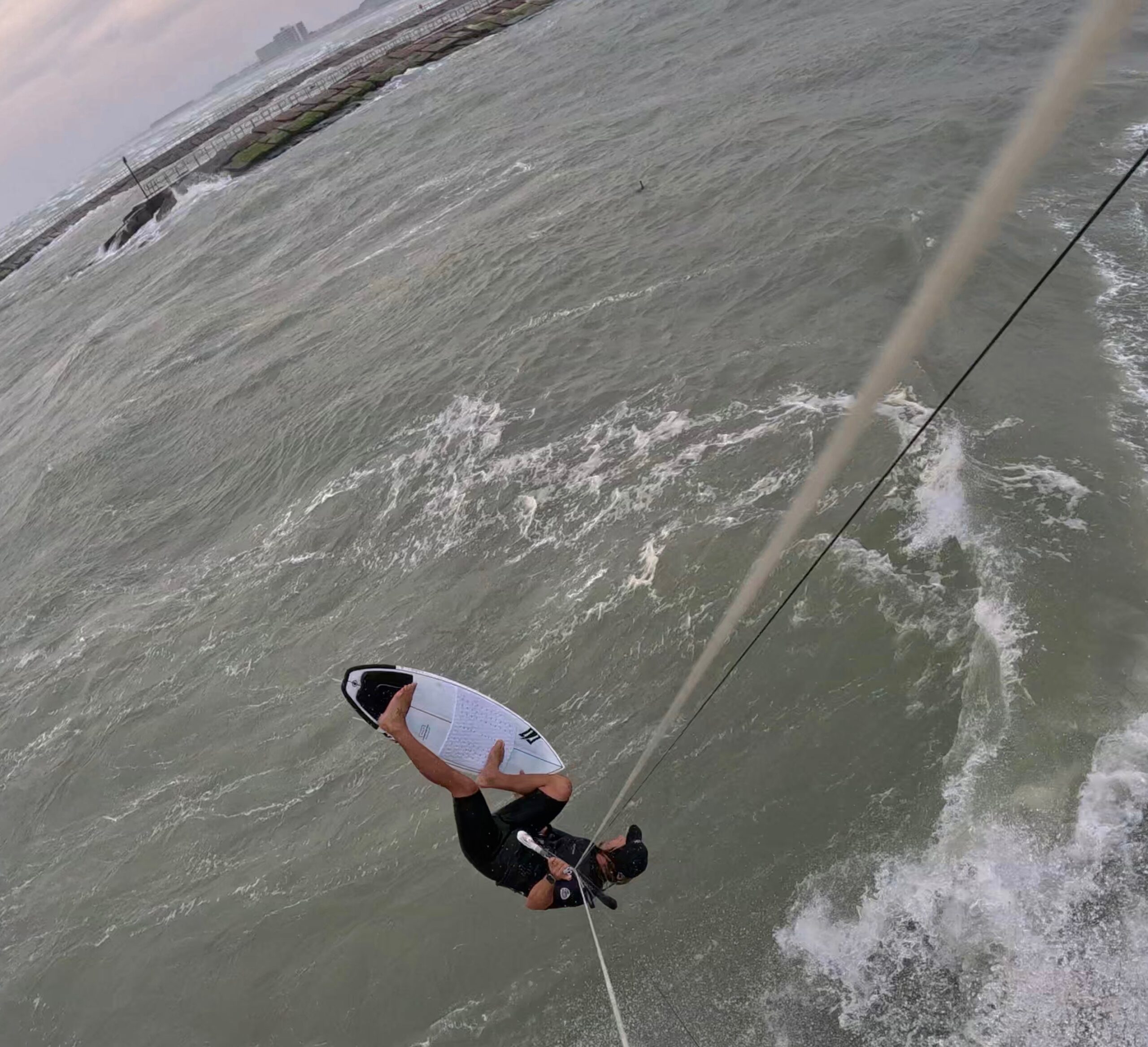 Kiteboarder riding chop near a jetty on the Texas Gulf coast