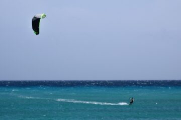 Lone kiteboarder riding a wide open bay with plenty of space