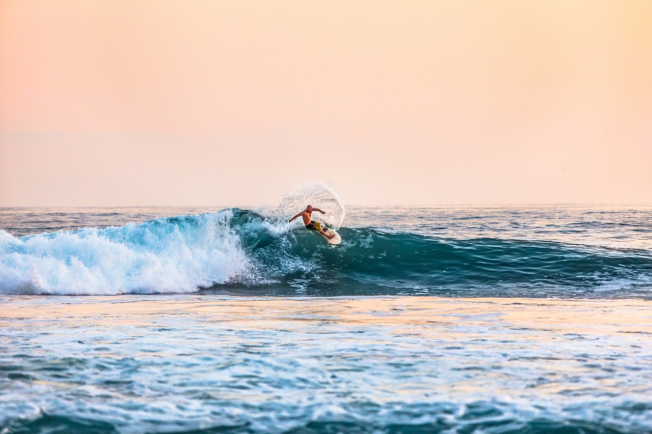 Surfer riding a small wave at sunset on the Texas Gulf coast